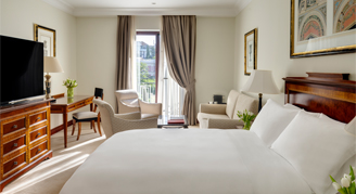 Castellana-view junior suite with king bed, seating are, and tv 