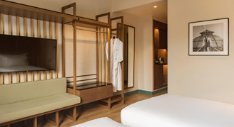 Two twin beds with seating and a television.