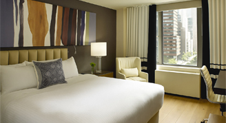 Image of one bed and nearby window in a Studio Apartment.