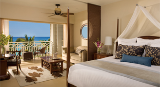 One king bed and seating area with a balcony beachfront view of the ocean.