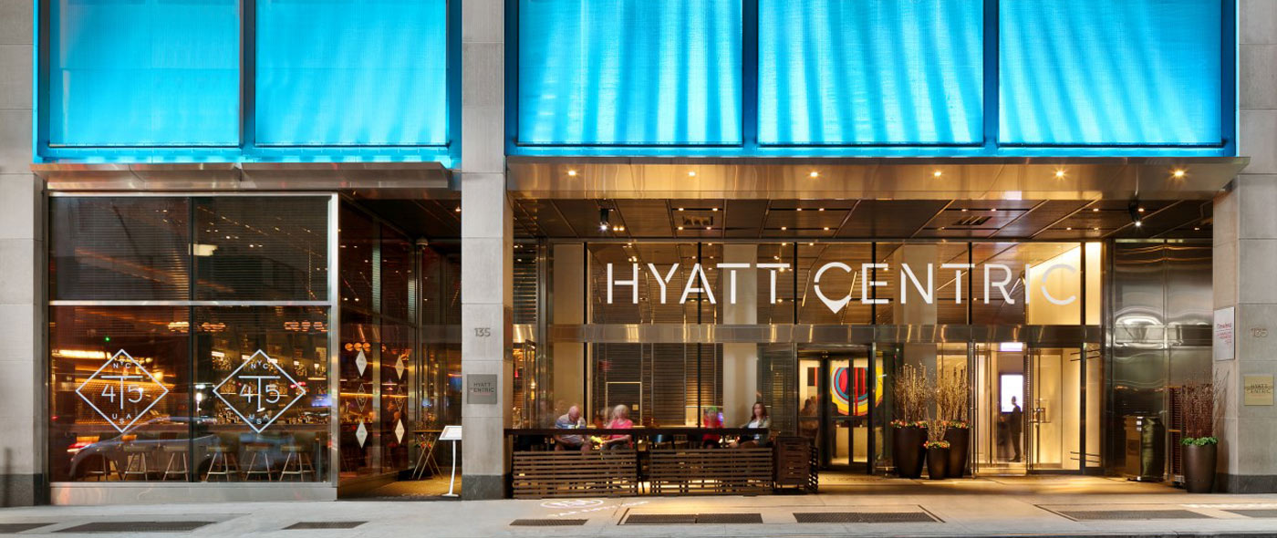 Photo of the hotel's exterior entrance with blue awnings.