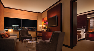 Image shows a living room area with a divider with the bedroom behind it.