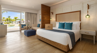 Photo of hotel room with king-sized bed and large balcony windows.