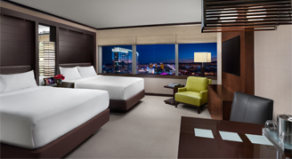 Image shows studio with two queen bed and arm chair.