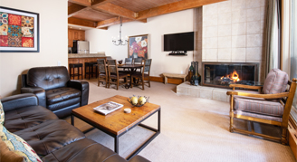 Photo of hotel living space with fireplace, couch, and dining area.