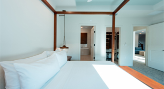 The image appears to show a modern bedroom with a wooden four-poster bed.