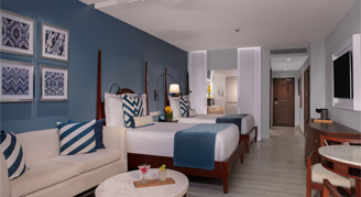 A two double bedroom with seating area and a bathroom with blue decor.