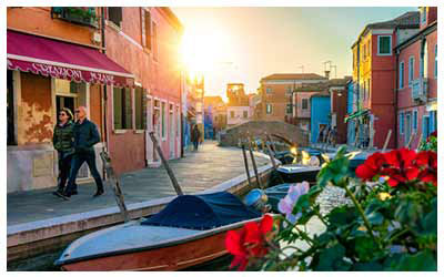 Image of a couple walking along a canal in Italy.