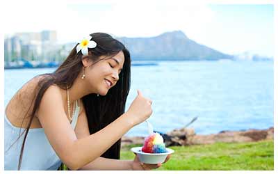 Young woman enjoying a shaved ice near Diamond Head on Oahu.