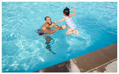 Image of a dad and daughter in a swimming pool.