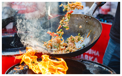 Image of food being stir fried in a wok.