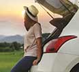 Image of a woman alone with a rental car.